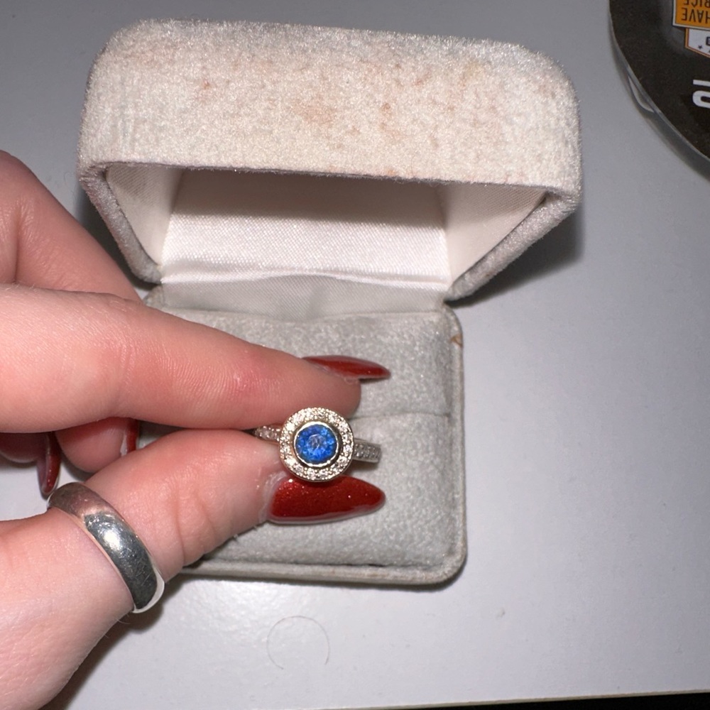 18k two toned gold sapphire ring with 29 diamonds within the band and halo.